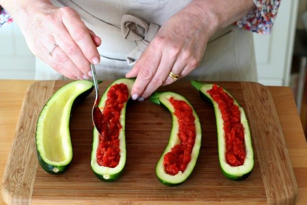 Die Zucchini mit der Tomatensauce füllen