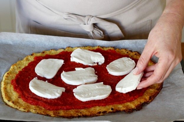 Den Mozzarella auf die Pizza geben