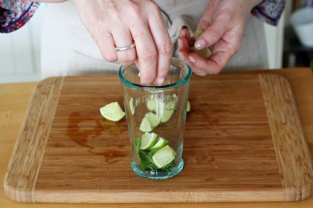 Die Limettenstücke ins Glas geben