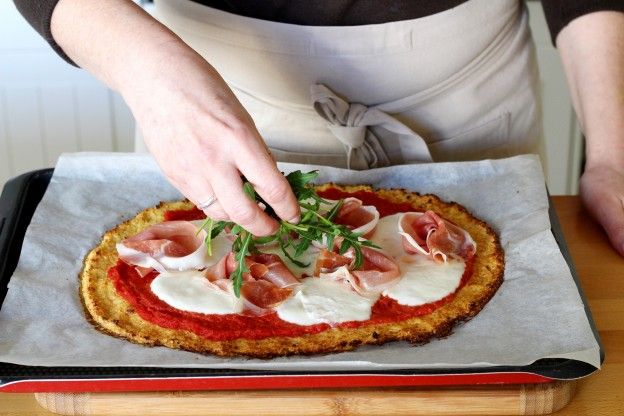 Den Rucola auf die Pizza geben