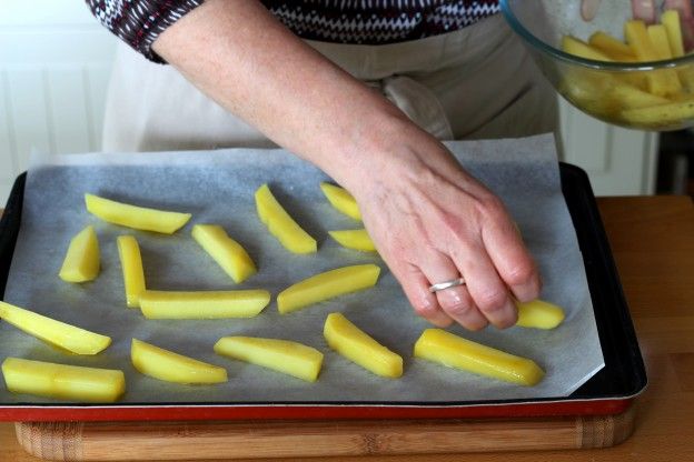 Die Kartoffelstifte auf einem Backblech verteilen