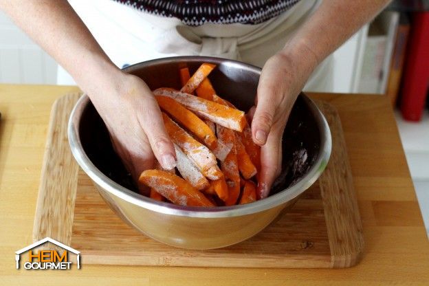 Das Öl und die Mehlmischung zu den Süßkartoffelstreifen geben und vermischen.