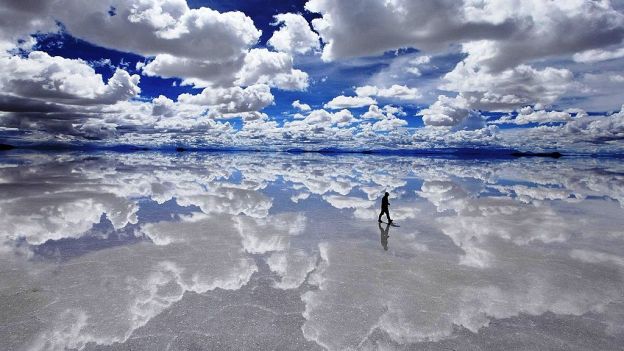 Bewundern das Spiegelbild des Himmels in Salar de Uyuni, Bolivien