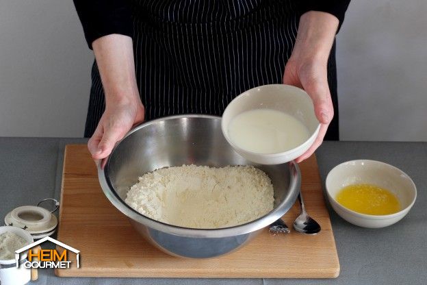 Lauwarme Milch in die Schüssel gießen.